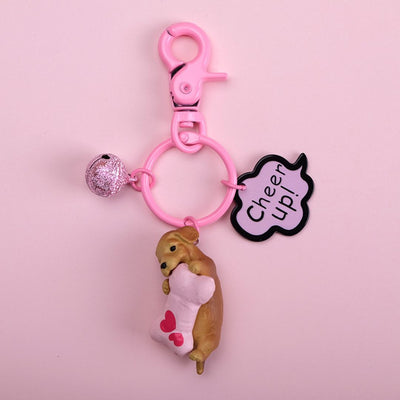 Keychain with a bear holding a heart and 'Cheer Up!' tag on a pink background