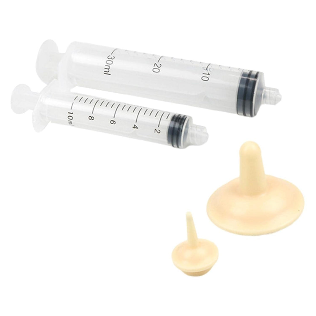 Two syringes with measurement markings and two beige silicone devices on a white background.